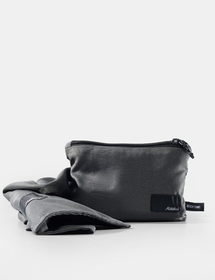 Matador NanoDry™ Packable Beach Towel - gray pouch with a label on a white background