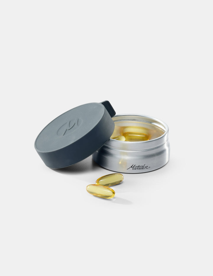 Matador Waterproof Travel Canister - 100ml - open container of supplements with pills on a white background