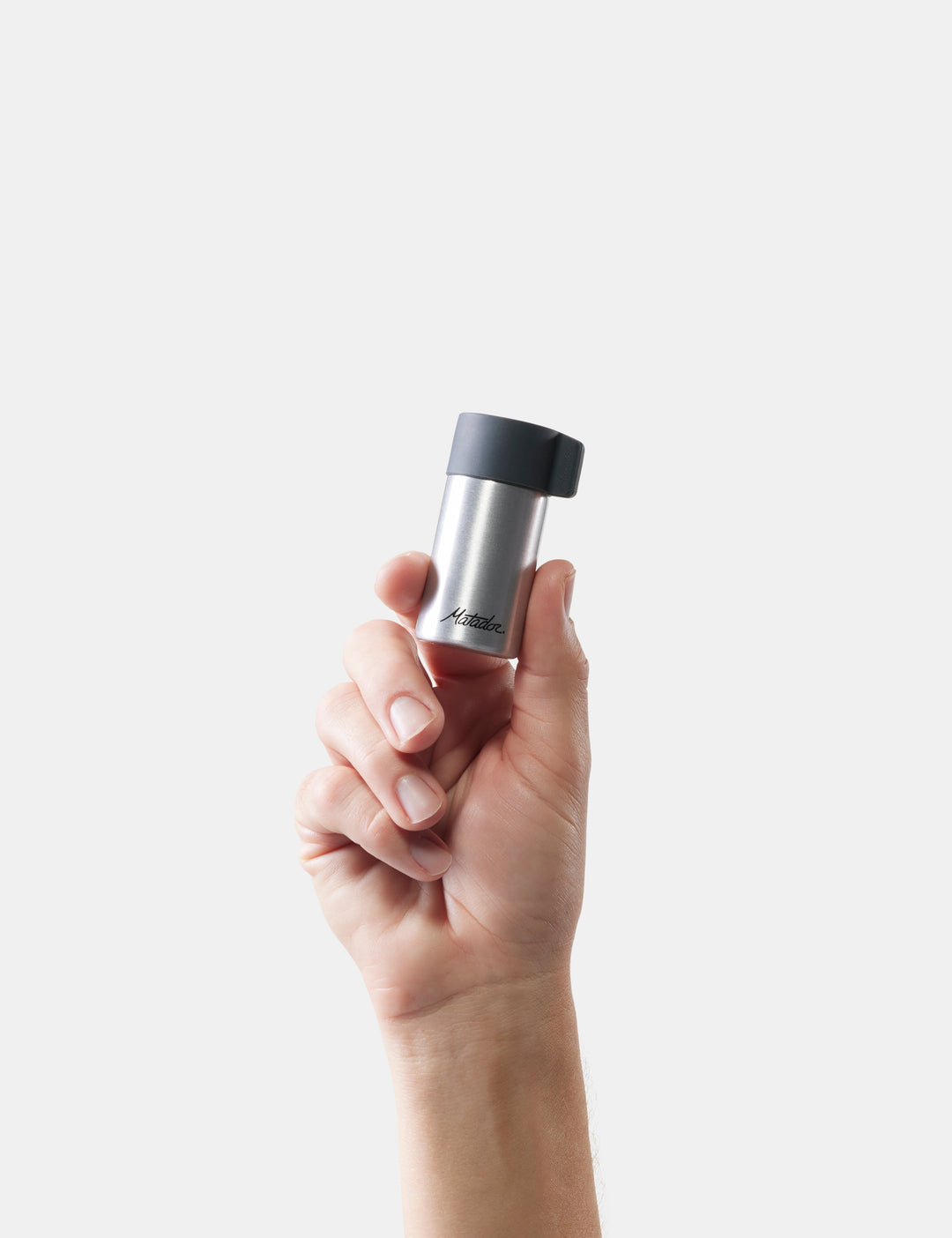 Matador Waterproof Travel Canister - 40ml - hand holding a silver and black container against a white background