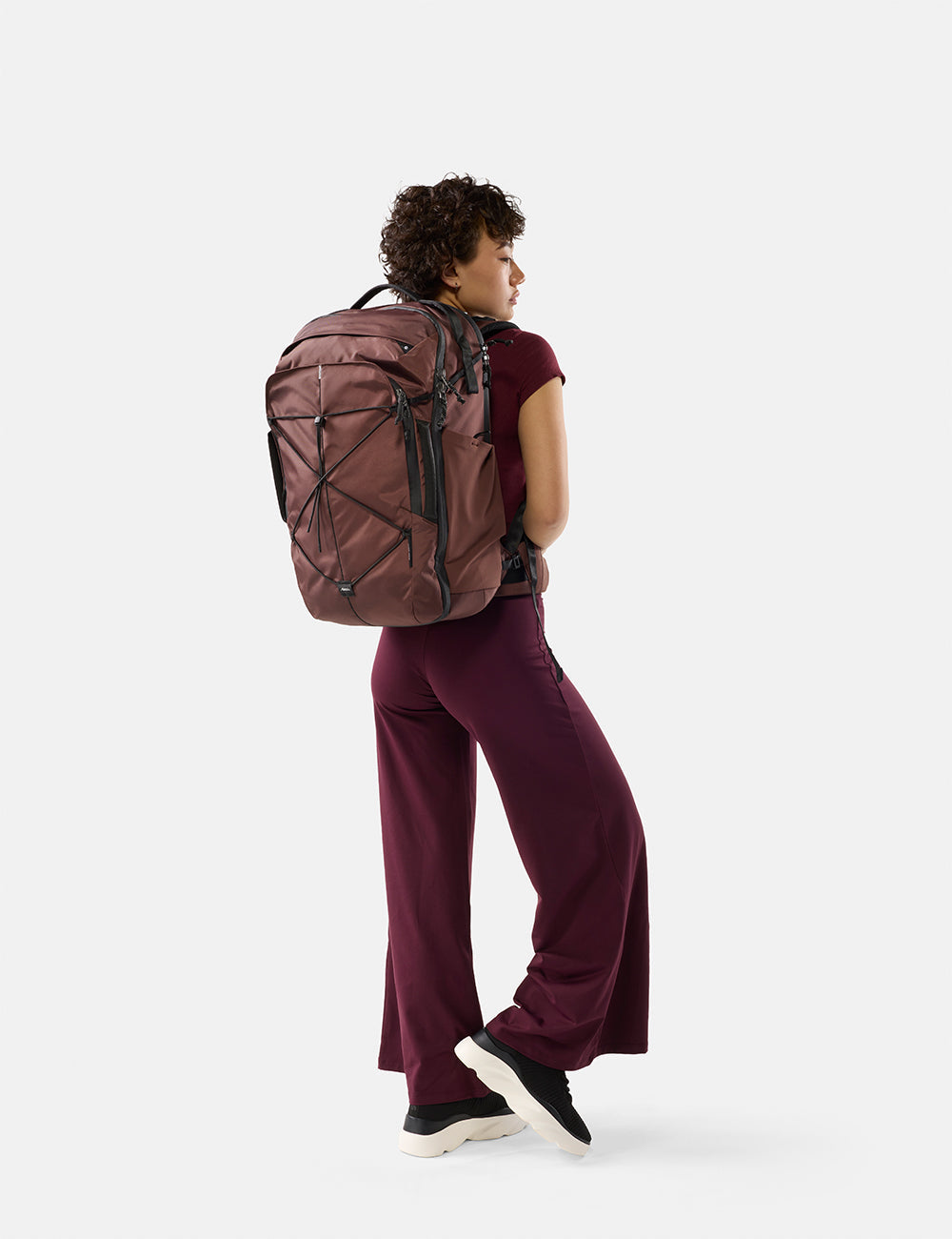 Matador 35L Global Travel Pack in Garnet - person wearing a garnet backpack on a white background