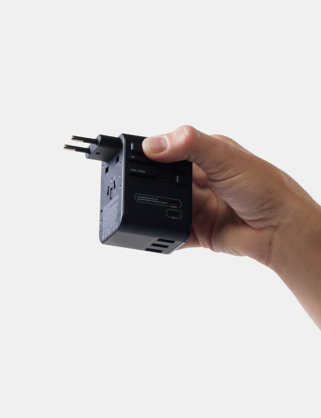 Matador Global Travel Adapter in Black - hand holding a black travel adapter against a white background