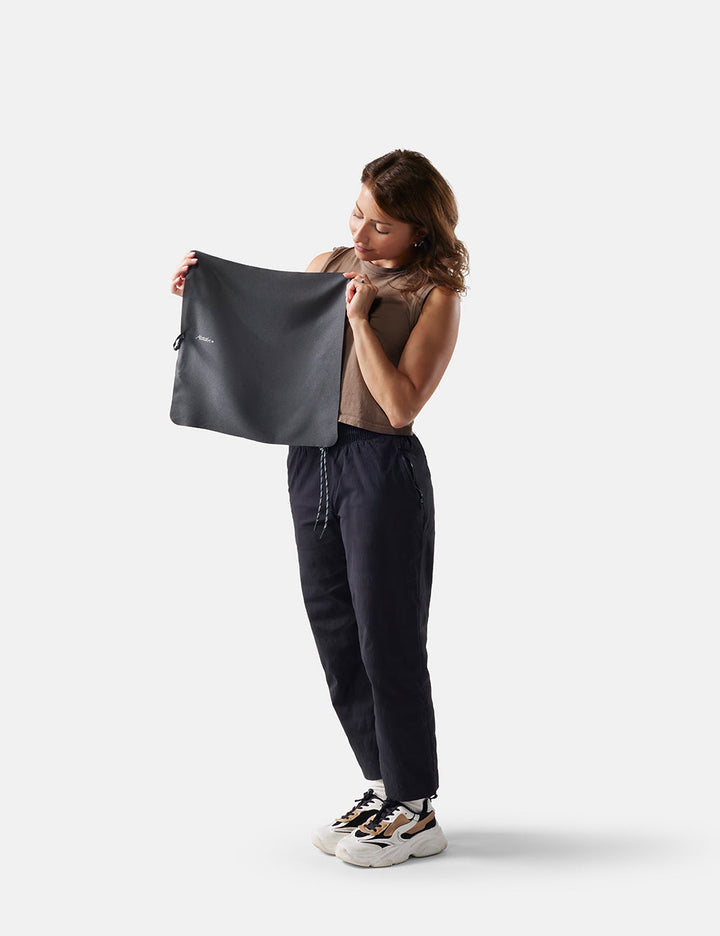 Matador NanoDry Towel - Small 39 x 39cm in Black Granite - woman holding small towel against a white background