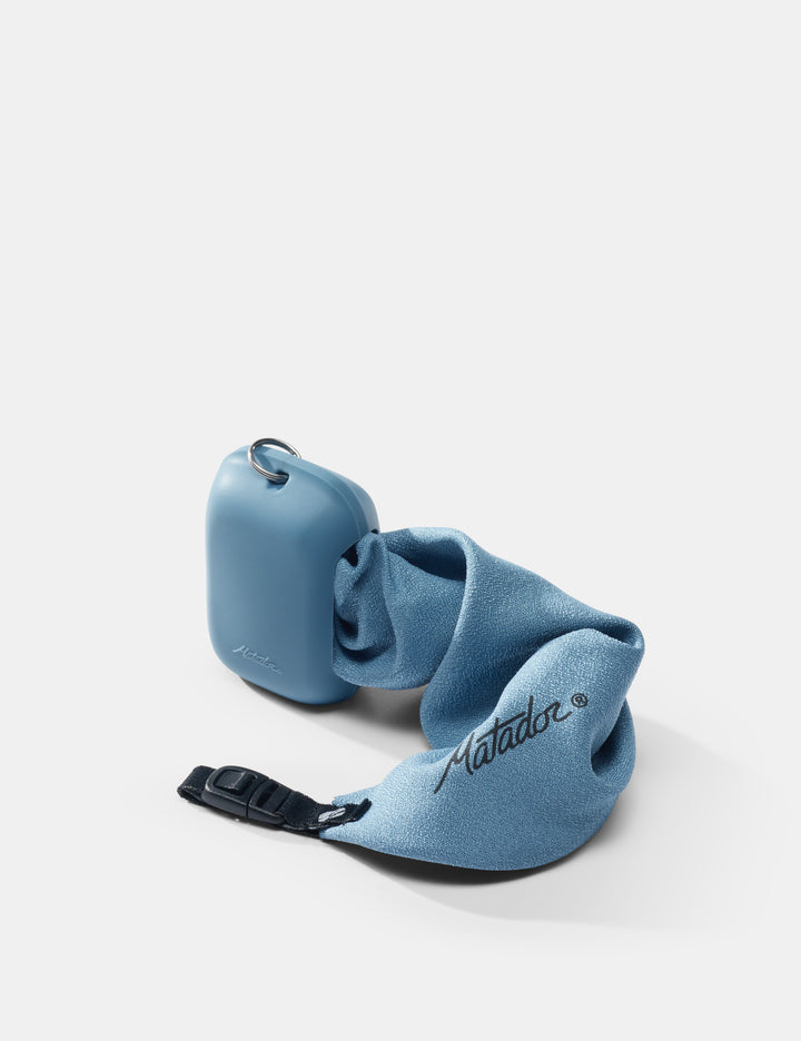 Matador NanoDry Towel - Small 39 x 39cm in Blue - slate towel coming out of silicone case on white background