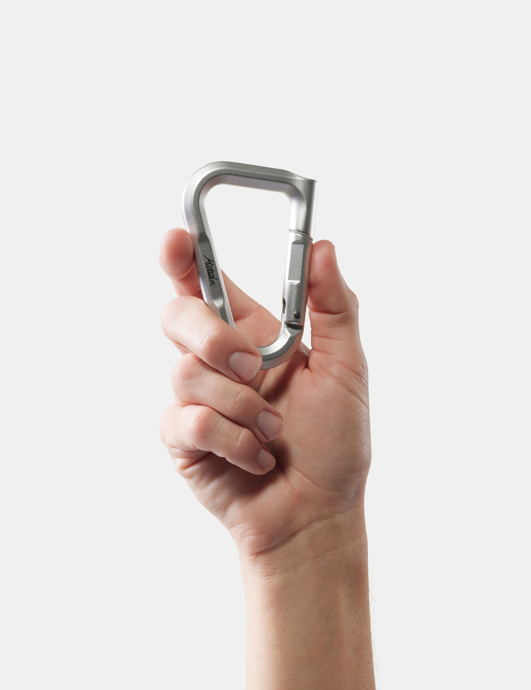 Matador BetaLock in Matte Black - hand holding a metallic carabiner against a white background