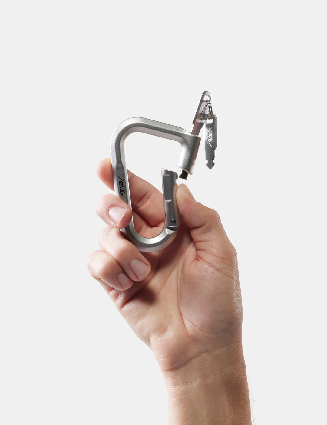 Matador BetaLock in Canyon Orange - hand holding a metal carabiner against a white background