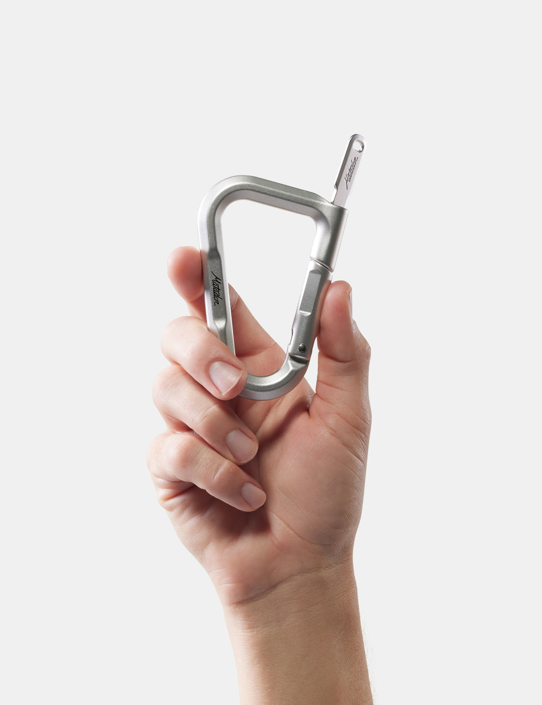 Matador BetaLock in Shadow Green - hand holding a silver carabiner against a white background