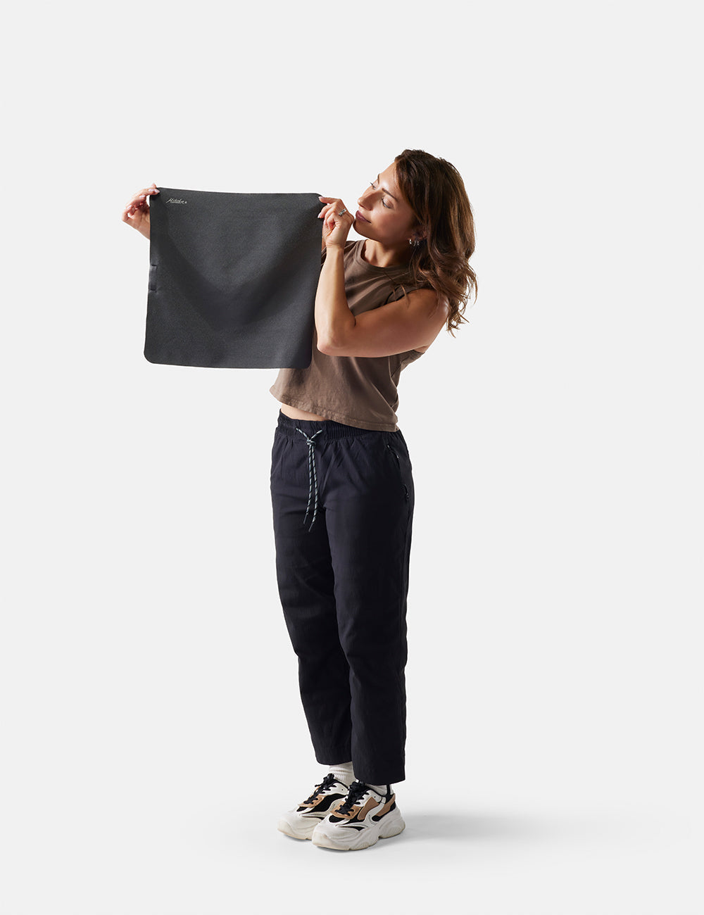 Matador Ultralight Travel Towel - Small 39 x 39cm - person holding a gray towel against a white background